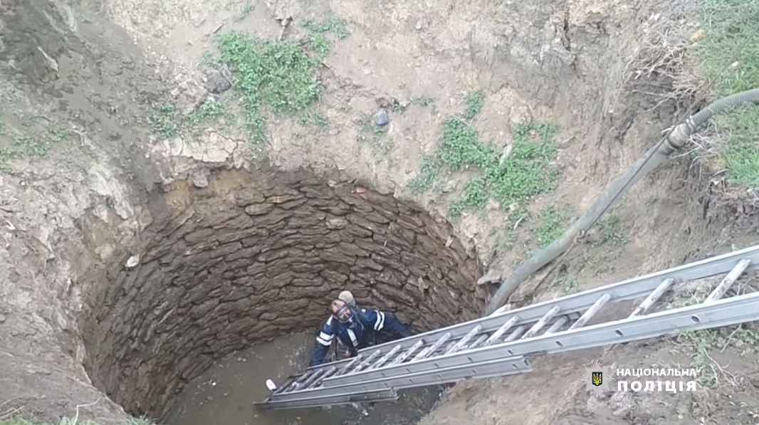 Спасатель достает тела погибших из колодца на Одесщине